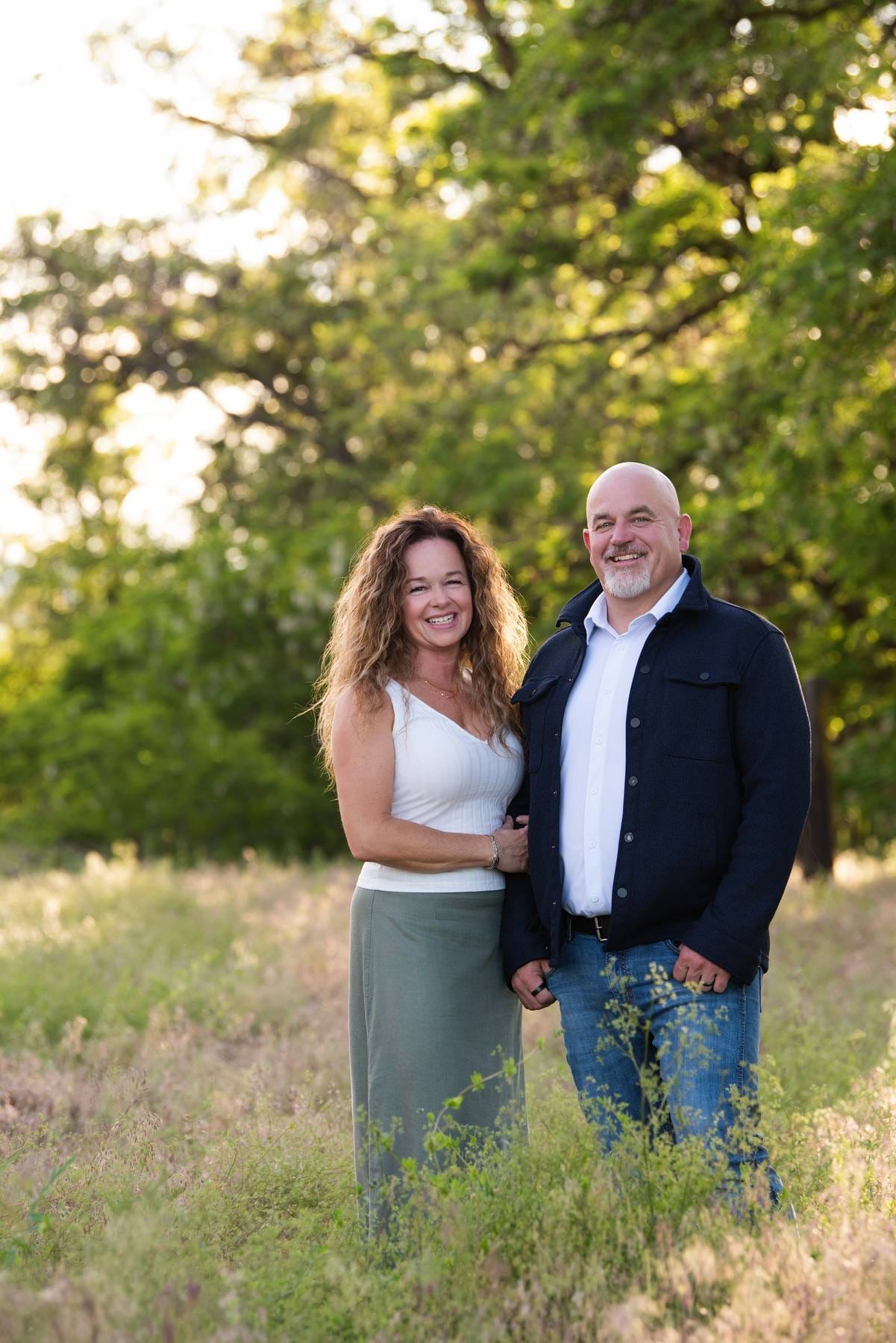 Mike and Kellie Baker standing together in a sunlit field